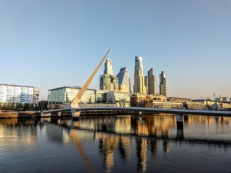 Modern waterfront bridge reflected in calm harbour water — Argentina