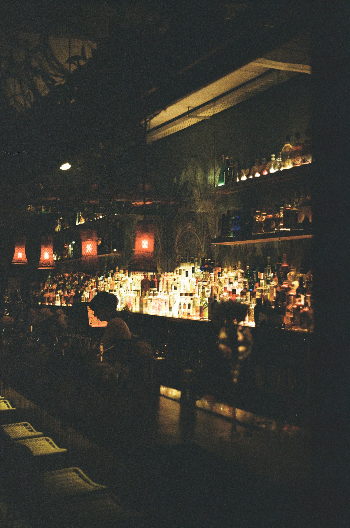 Dark atmospheric bar with illuminated bottles and red lamps — Buenos Aires nightlife