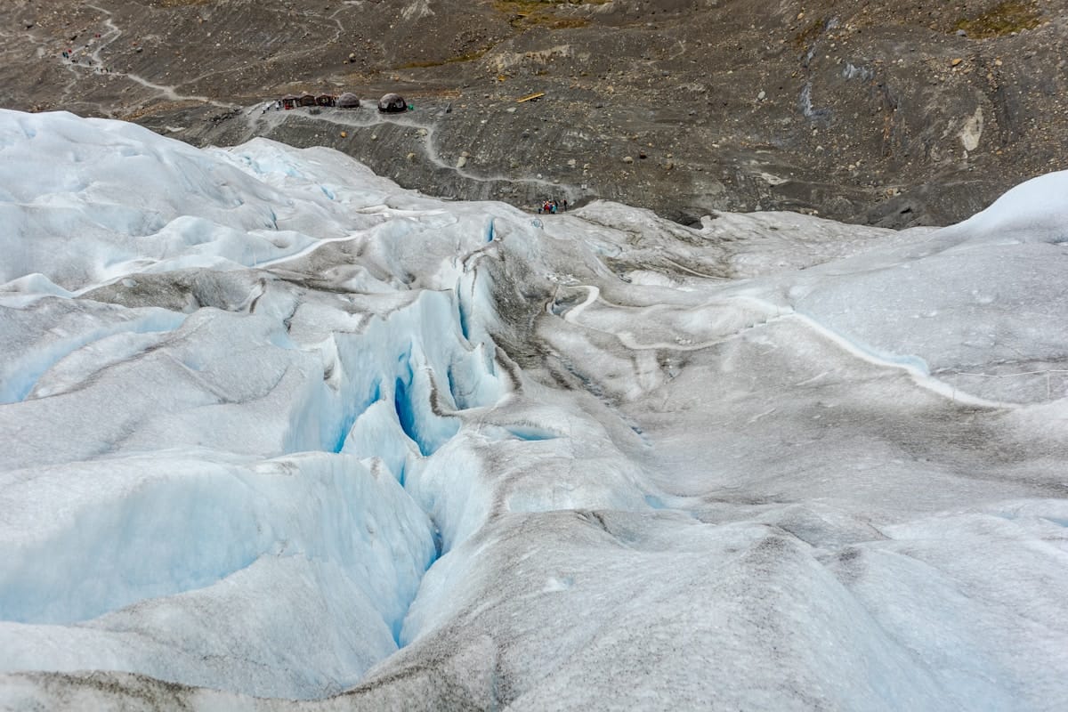 Blue ice crevasses on Perito Moreno glacier with trekking guides and visitors on the surface above, El Calafate, Argentine Patagonia