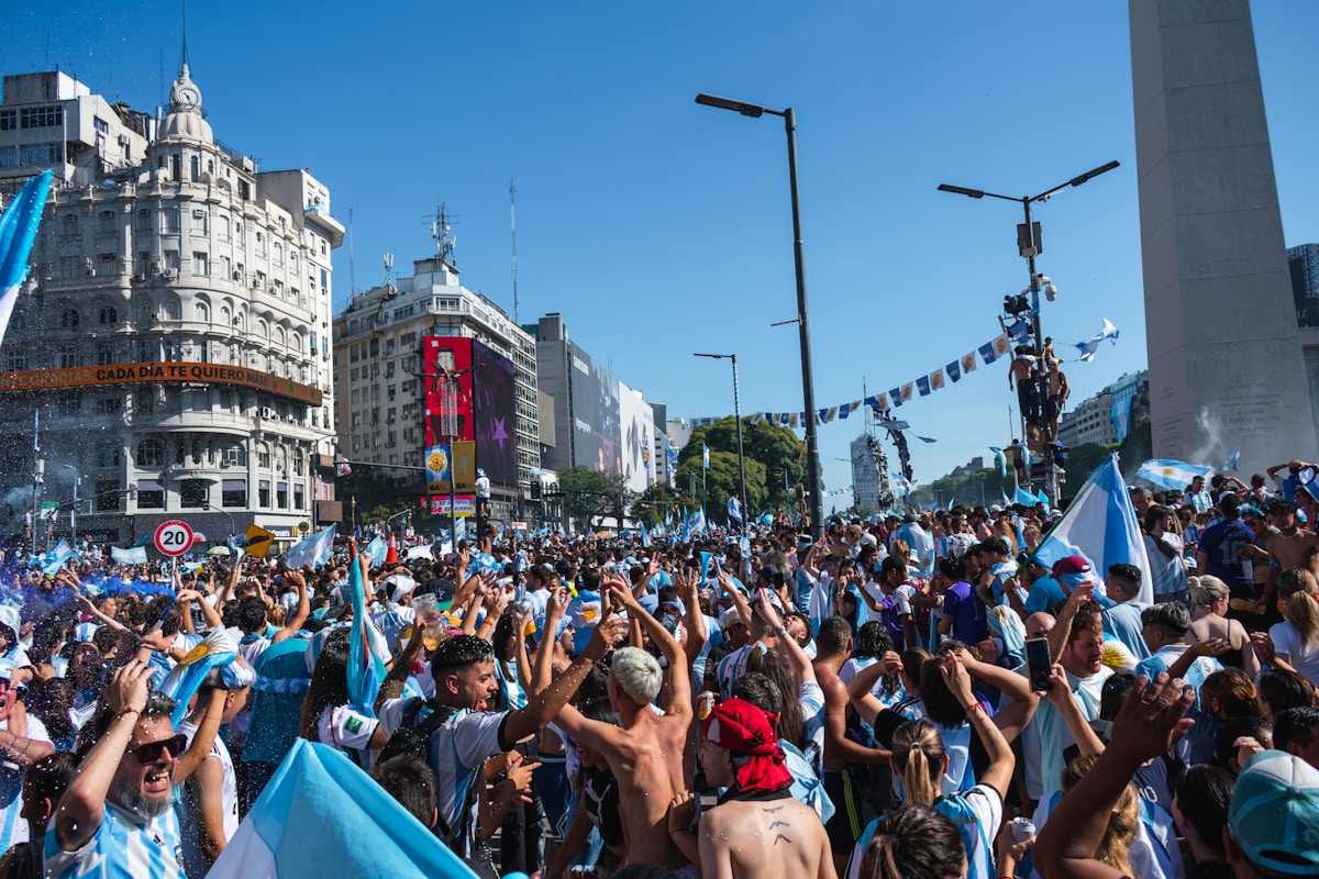 Argentine football fans celebrating on Avenida 9 de Julio in Buenos Aires with the Obelisco behind
