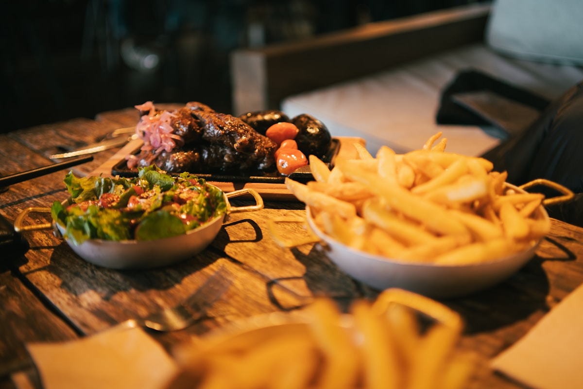Restaurant meal with grilled meat, salad and fries on a wooden table in Patagonia, Argentina