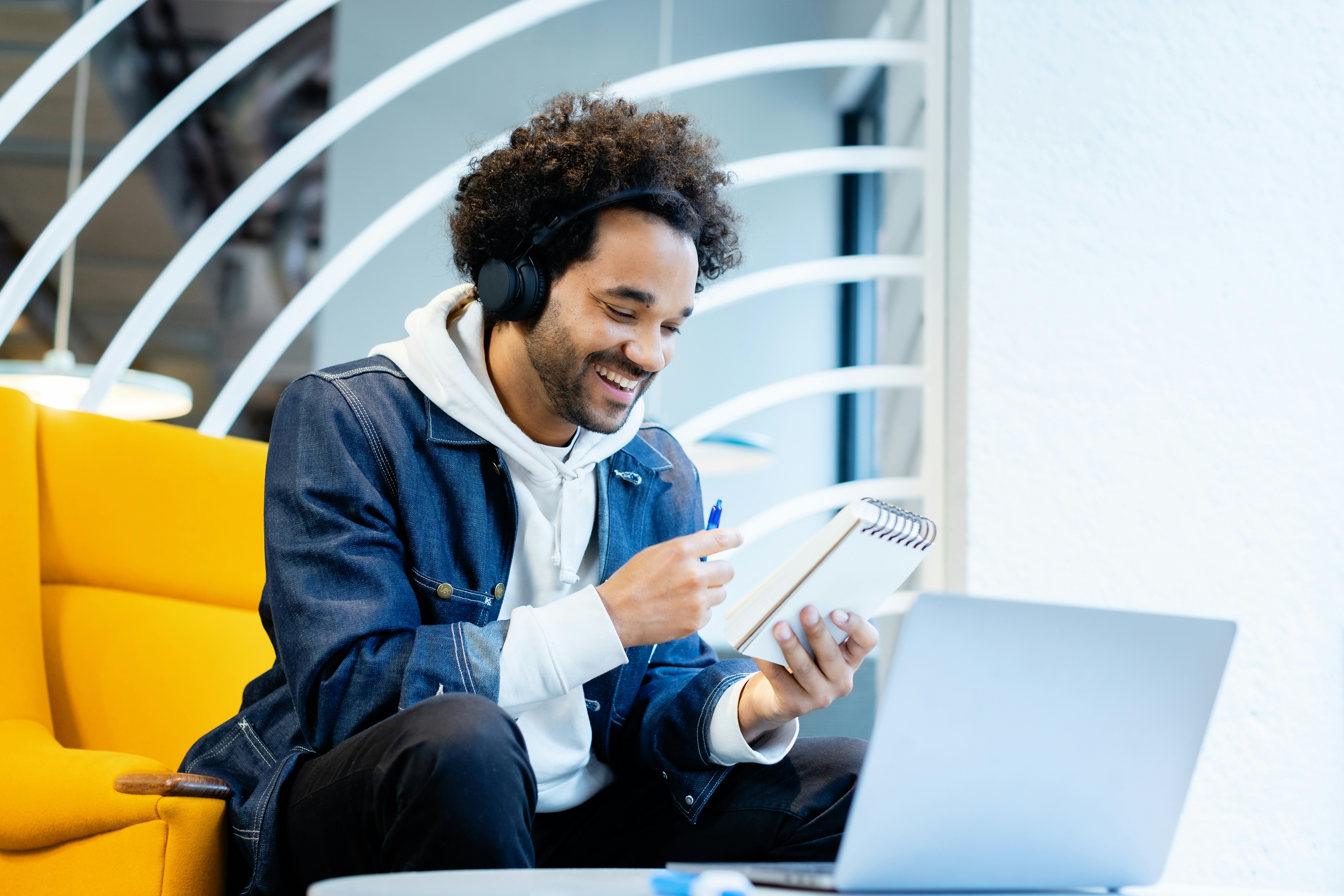 Young remote worker with headphones and laptop in a modern coworking lounge — typical of Córdoba's university-city digital nomad scene