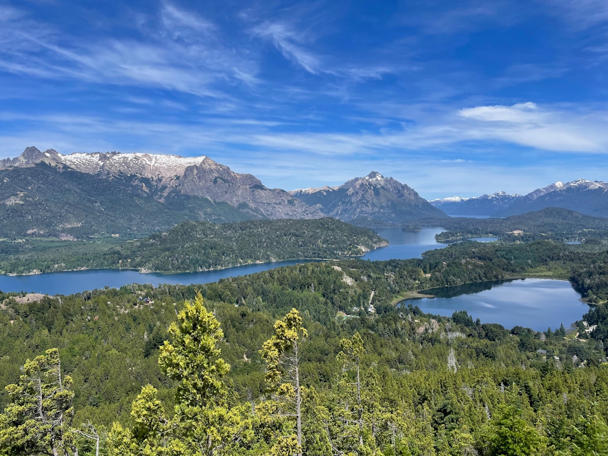 Panoramic view of Nahuel Huapi Lake surrounded by lush forest and snow-capped Andean peaks, Bariloche, Patagonia, Argentina
