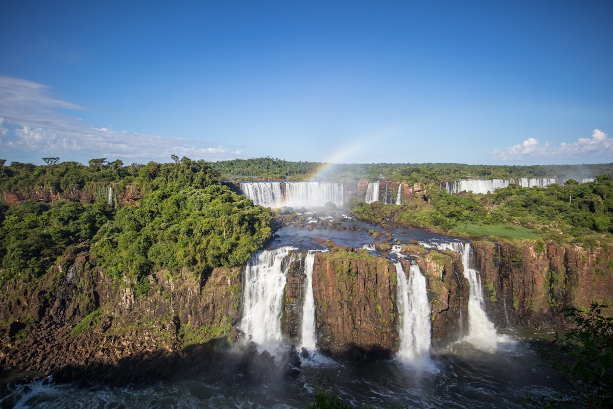 Iguazu Falls cascading through lush subtropical jungle with a rainbow over the mist, Misiones Province, Argentina
