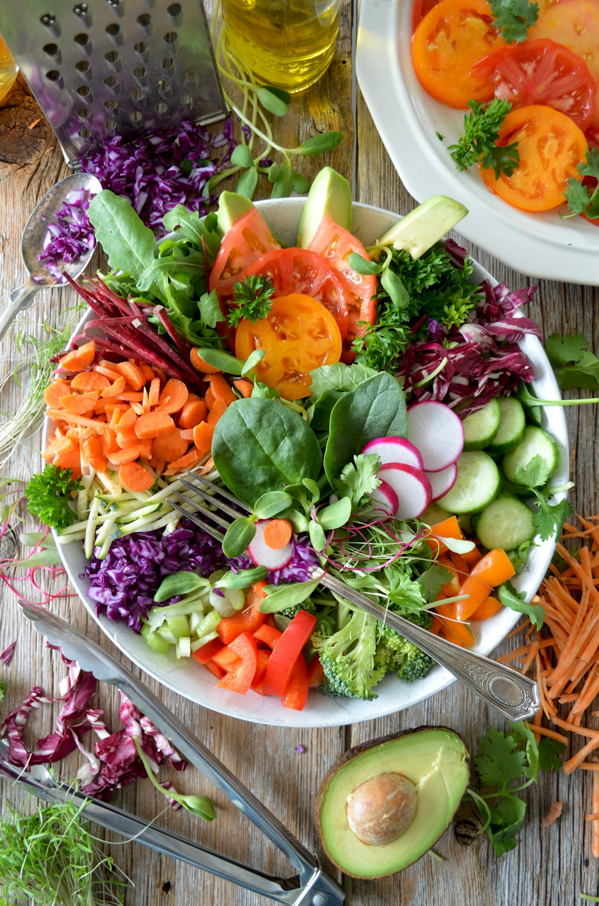 Colourful salad with avocado, radishes and seasonal vegetables on a wooden table