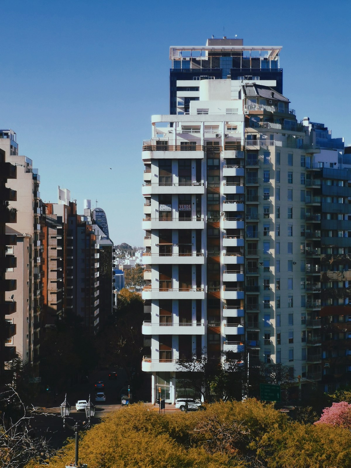 Tall white building beside a lush green park, Córdoba, Argentina